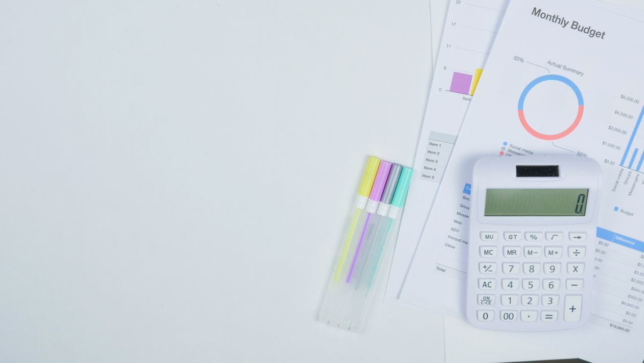 Small business owner planning a marketing budget with a calculator and notebook