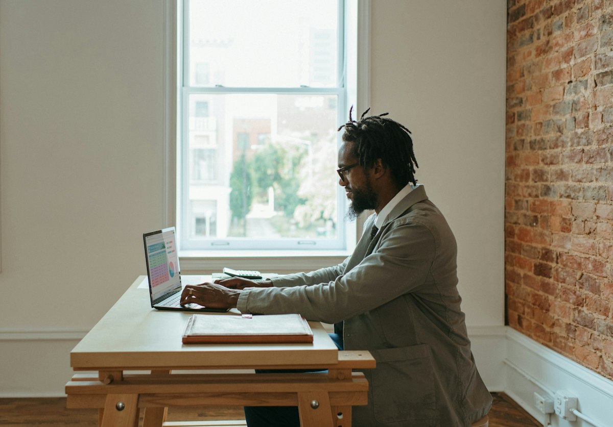Small business owner reviewing her website on a laptop in a modern office
