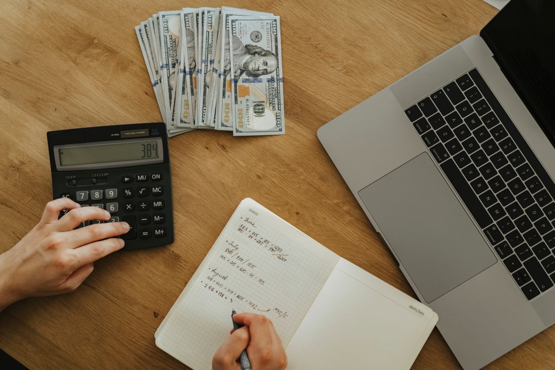 Notebook, calculator and coffee on a desk while planning small business spending