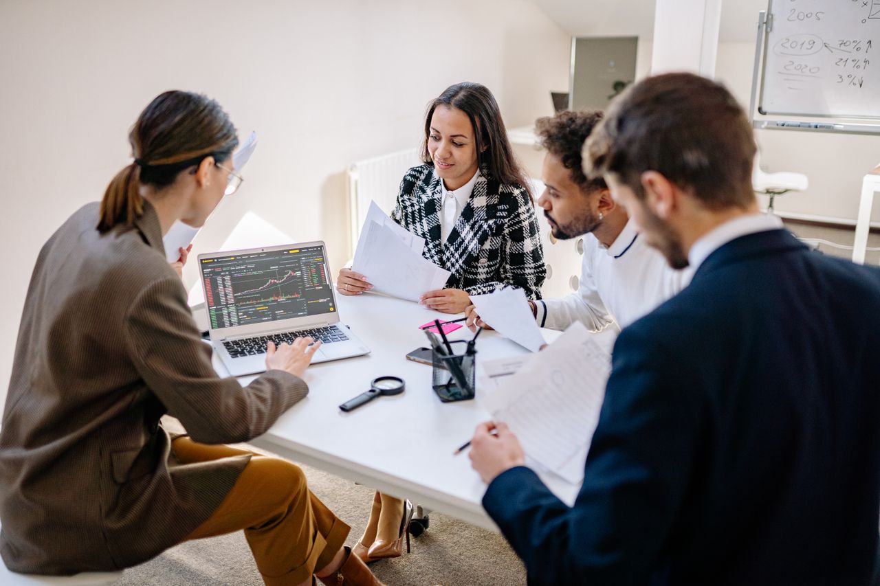 Business professionals reviewing customer records on a laptop in an office
